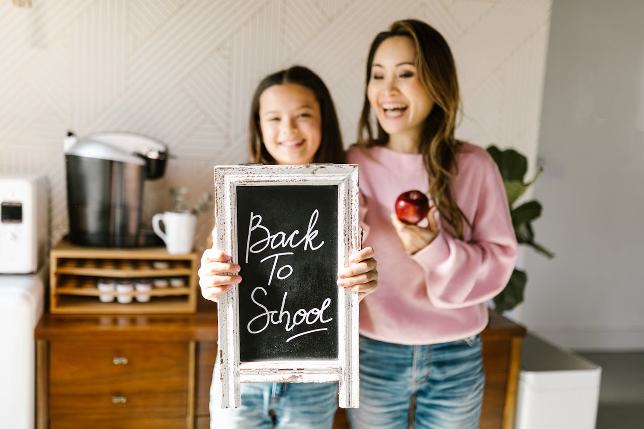Happy mother and daughter enjoying back to school moment indoors.